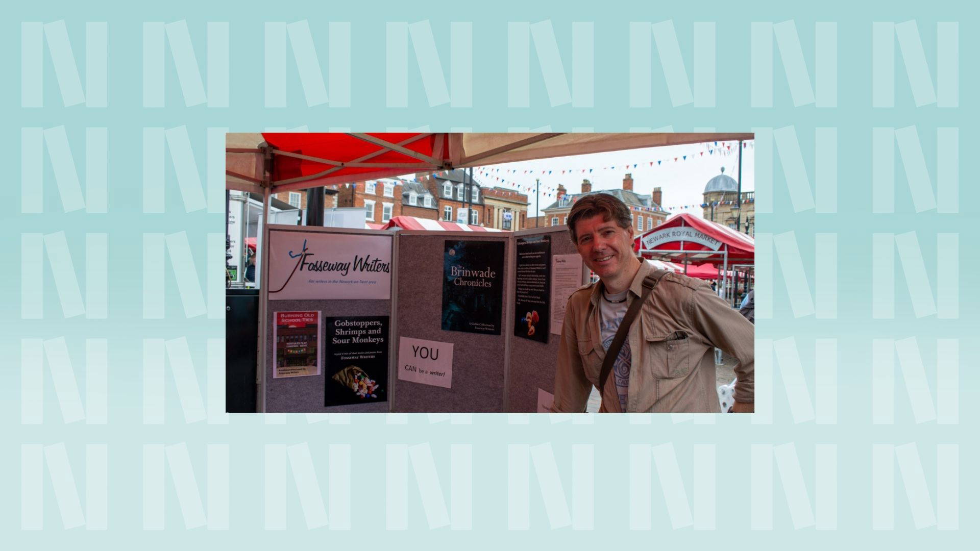 The background is light blue with the "N" logo for Newark Book Festival and a pink banner at the bottom of the photograph says their name.